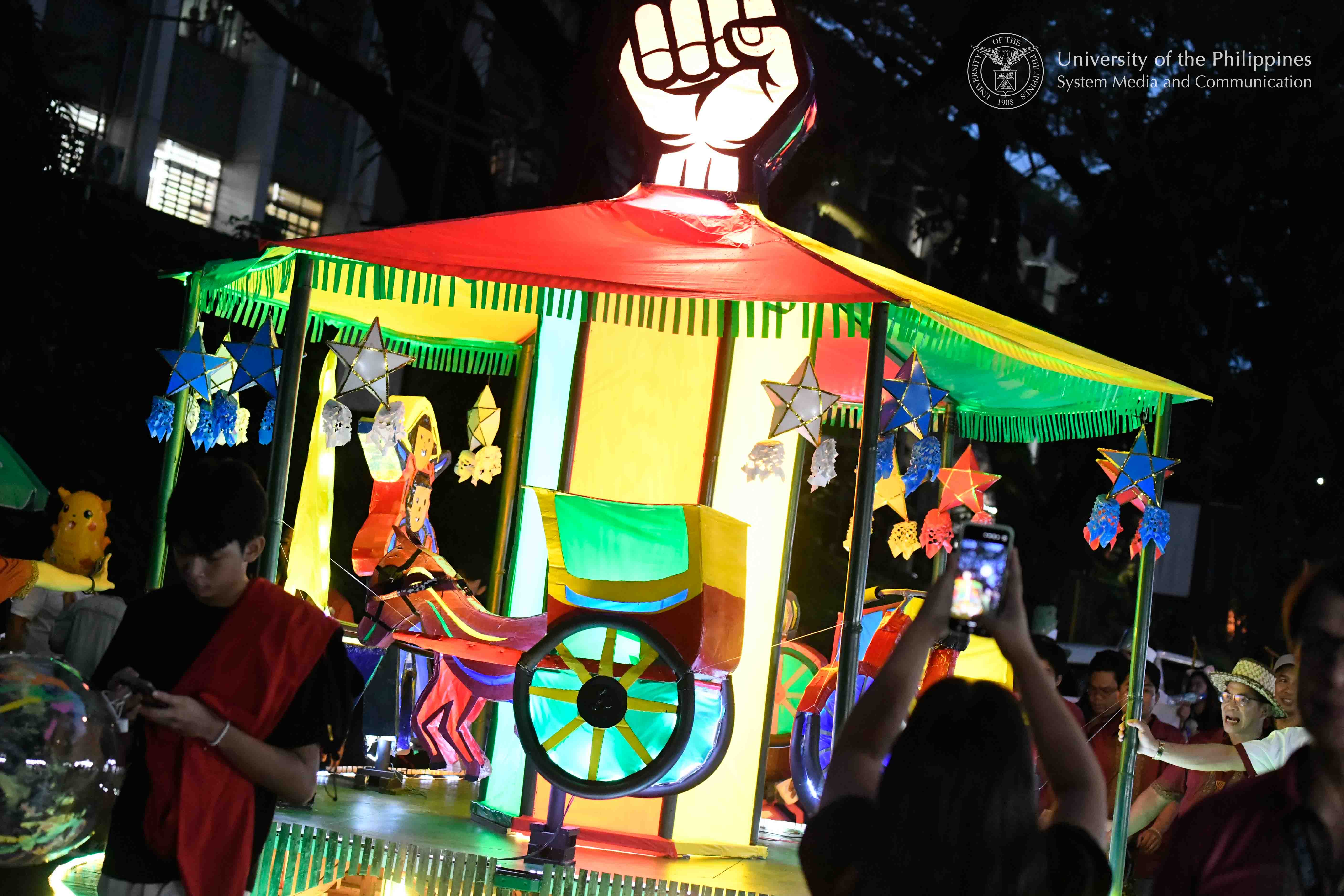 The carousel-themed lantern “Abé-abé sa KALsada” of the UP Diliman College of Arts and Letters won first place in this year’s Lantern Parade. CAL’s lantern, designed by Asstistant Professor John Carlo Pagunaling and Nap Rivera, is a “manifesto of material reclamation” which utilizes discarded cardboard and organic bamboo to transform urban waste into a symbol of resilience. Photo by Kevin Roque, UPS-MCO.