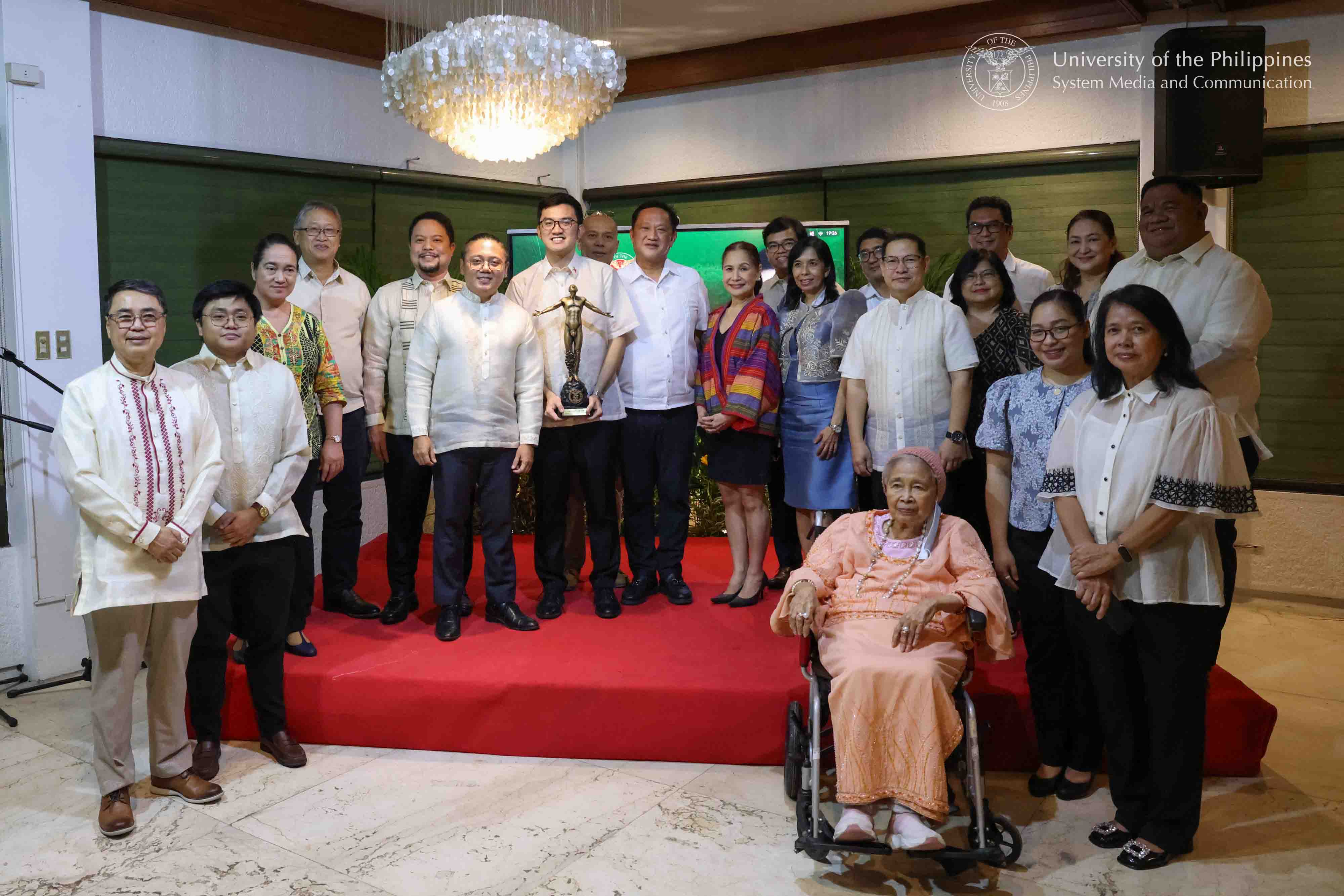 UP NCPAG administrators and faculty pose for a group photo with DBM Secretary Kim Robert de Leon (holding UP Oblation statuette). Photo by Kevin Roque, UPS-MCO.